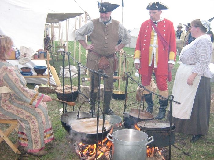 Kochstelle mit mehreren Töpfen und Darstellern